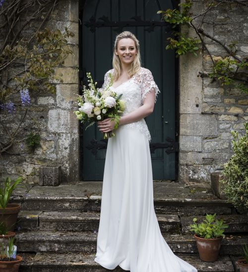 A beautiful bride poses whilst holding a bouquet of flowers