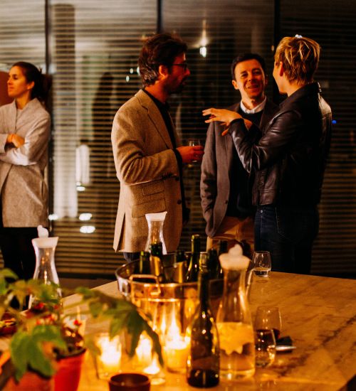 Colleagues conversing over a drink at a corporate event