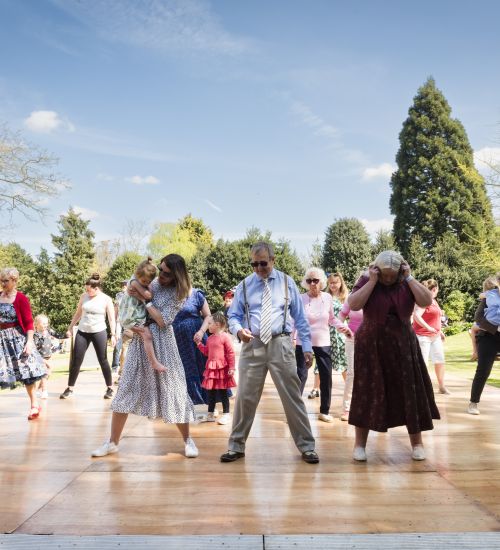 A group of people dancing under blue skies at Grantham House