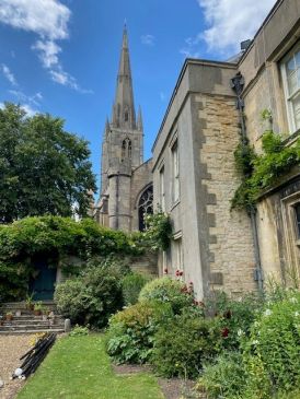 Looking up at St Wulfram's church spire from a scenic garden